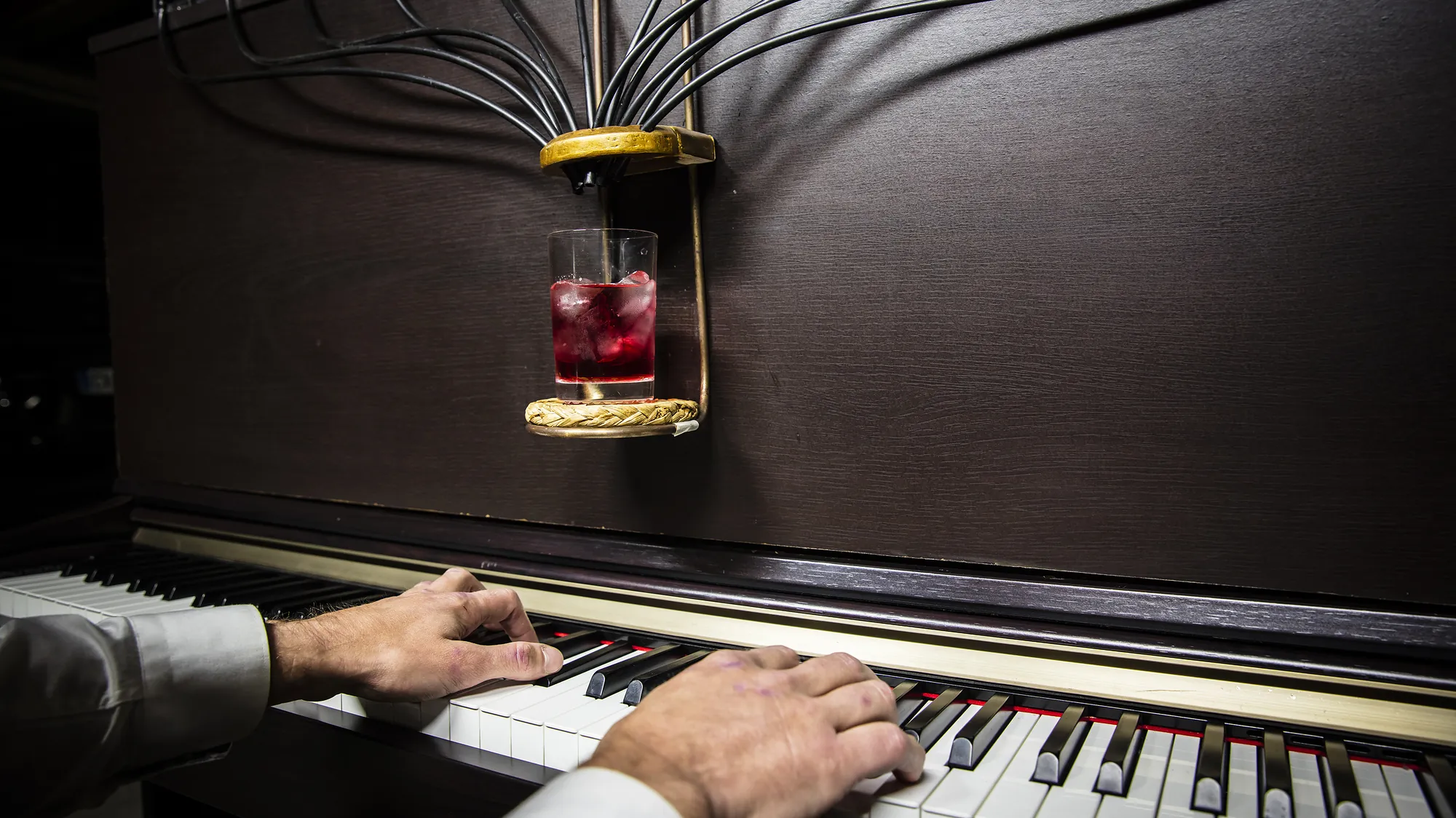 Cocktail signature servi au-dessus du clavier pendant que le pianiste joue