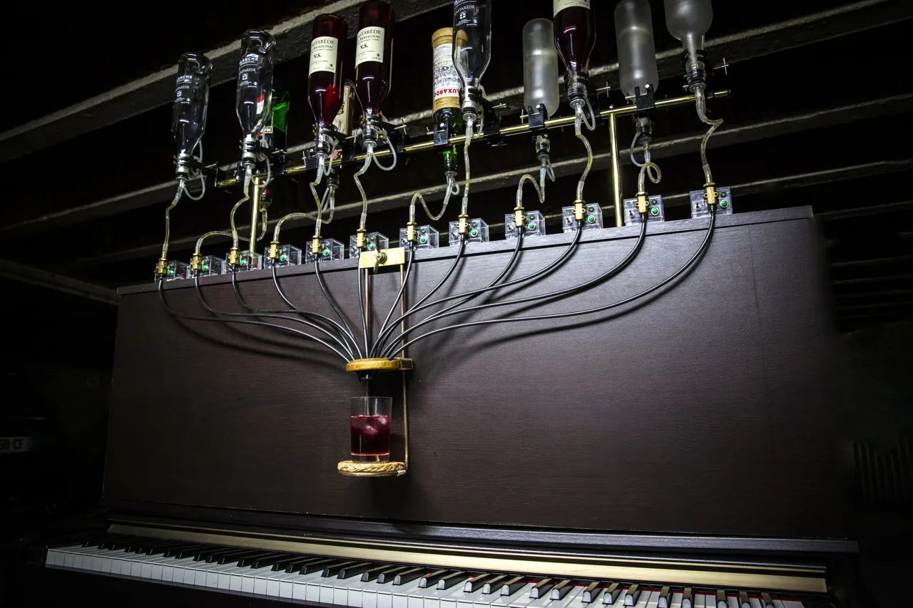 Le Pianocktail, piano qui fait des cocktails : bouteilles, tubes et verre au-dessus du clavier