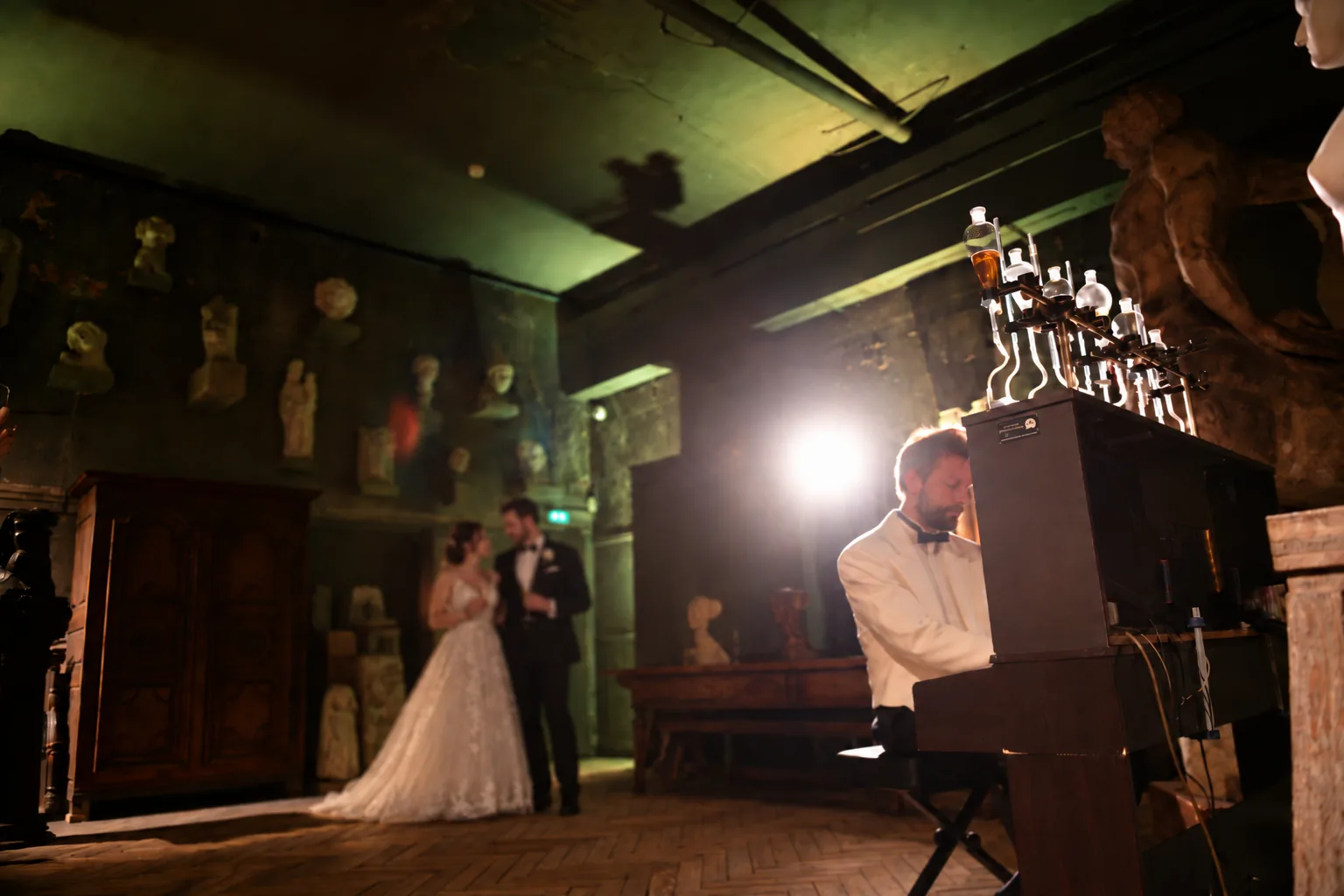 Les mariés enlacés écoutent le pianiste jouer le Pianocktail dans un atelier de sculptures