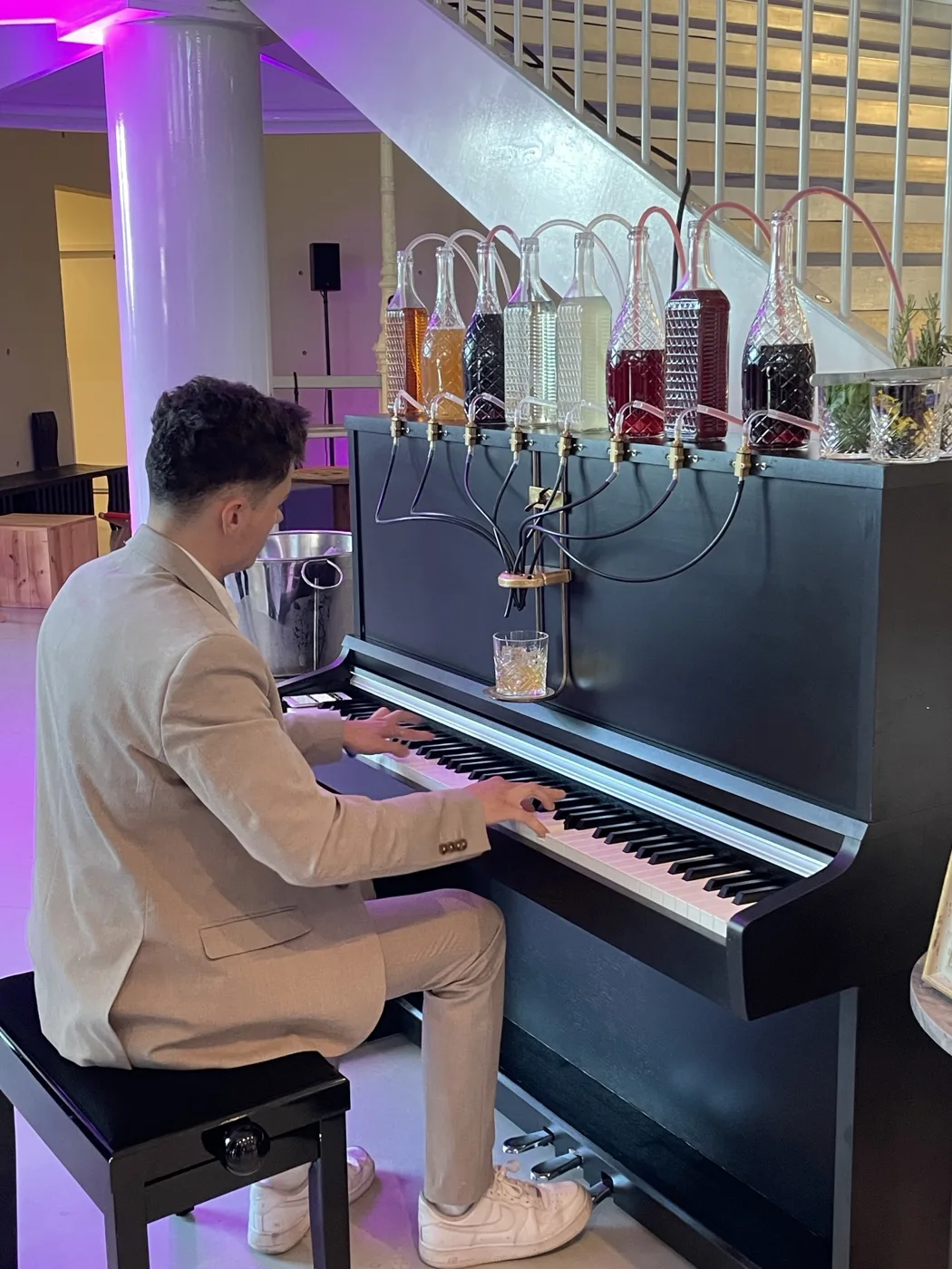 Le pianiste joue le Pianocktail lors d'une soirée d'entreprise, huit bouteilles reliées au verre